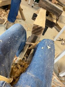 Sitting at the shaving horse, making big pieces of wood smaller
